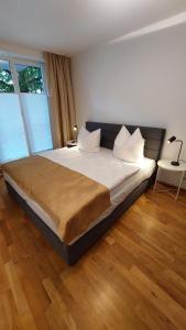 een groot bed in een kamer met houten vloeren bij Ferienresidenz Brauneberger Hof in Brauneberg