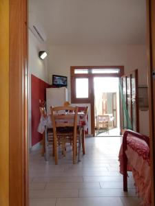 una cucina e una sala da pranzo con tavolo e sedie di Casa Ventitre a Campo nell'Elba