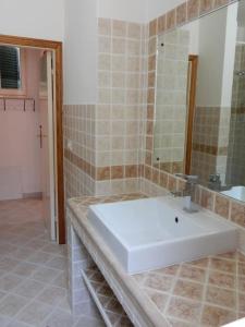 bagno con lavandino bianco e specchio di Casa Ventitre a Campo nell'Elba