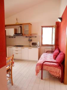 una piccola cucina con un letto in una camera di Casa Ventitre a Campo nell'Elba