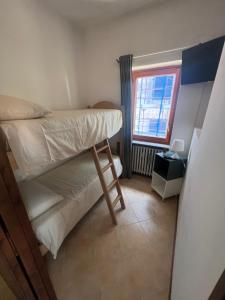 1 dormitorio con litera y ventana en Casa Vacanza Regina, en Roccaraso