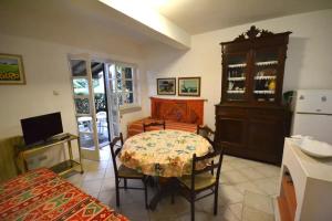 um quarto com uma mesa e uma cozinha com um frigorífico em Bilocale a due passi dalla spiaggia em Marina di Campo