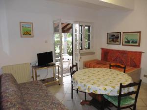 uma sala de estar com uma mesa e uma cama em Bilocale a due passi dalla spiaggia em Marina di Campo