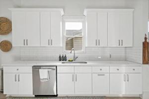 Una cocina con gabinetes blancos y un fregadero y una ventana. en Urban Elegance Retreat, en San Antonio 29 fotos más