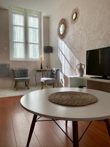 salon ze stołem i telewizorem w obiekcie Chouette Appartement Dijon Centre w mieście Dijon