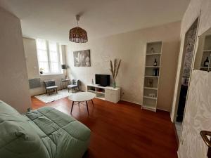 uma sala de estar com um sofá e uma mesa em Chouette Appartement Dijon Centre em Dijon