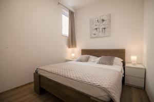 a bedroom with a large bed with two lamps on it at Apartments Teskera in Bol