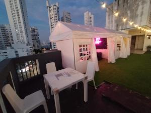 a white tent on a rooftop with a table and chairs at 1IF2-2APARTAMENTO EN CARTAGENA CERCA AL MAR CON AIRE ACONDICIONADO Y WIFi in Cartagena de Indias