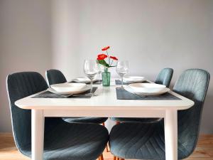 a table with chairs and a white table with wine glasses at Parkcity Chorzów in Chorzów