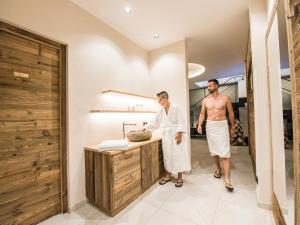 deux hommes debout à un comptoir dans une salle de bains dans l'établissement Apartment Sella, à Alpe di Siusi