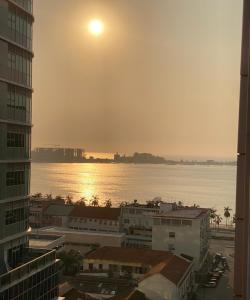 een uitzicht op de oceaan vanuit een stad met de zonsondergang bij The Queen in Luanda