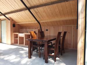 a wooden table and chairs in a cabin at Natuurslaapkamer de zaadeest boskamer in Lomm +21 photos