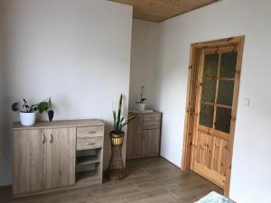 Habitación con armario de madera con macetas y puerta. en Apartmán Karhule (pod Blaníkem) 
