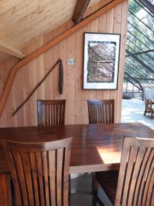uma sala de jantar com uma mesa de madeira e cadeiras em Natuurslaapkamer de zaadeest boskamer em Lomm