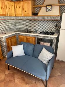 Un sofá azul con dos almohadas en la cocina en Casa Vacanza Regina en Roccaraso