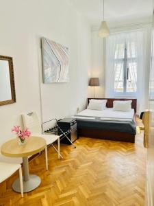 a bedroom with a bed and a table and chairs at City Rooms in Budapest