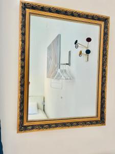 a mirror with a gold frame hanging on a wall at City Rooms in Budapest