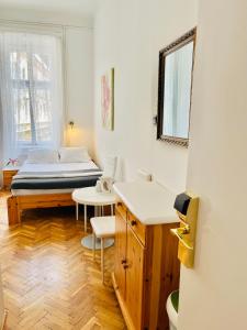 a bedroom with a bed and a table and a mirror at City Rooms in Budapest