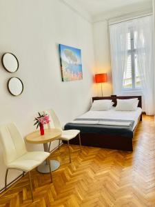 a bedroom with a bed and a table and chairs at City Rooms in Budapest