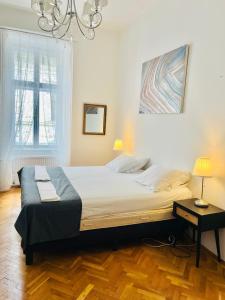 a large bed in a bedroom with a chandelier at City Rooms in Budapest