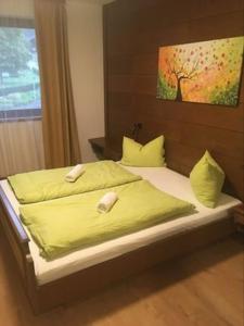 Aineterhof في Ainet: سرير مع أغطية ومخدات صفراء في غرفة النوم