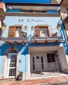 un edificio azul con 2 balcones en La Piazzetta, en Giardini Naxos
