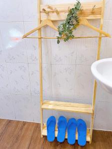 um par de sapatos azuis numa prateleira ao lado de um lavatório em Mai Anh Homestay Long Hải em Long Hai