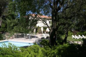 einen Pool mit Liegestühlen und einem Baum in der Unterkunft Le Laou in Mimet