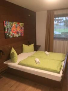 Un dormitorio con una cama con sábanas verdes y una ventana en Aineterhof, en Ainet