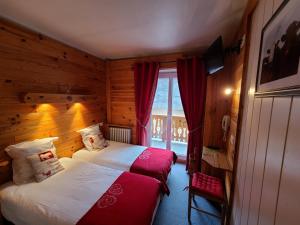 a hotel room with a bed and a window at Hôtel du Centre in Valloire