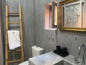 a bathroom with a sink and a mirror and a toilet at YVES Marrakech in Marrakesh