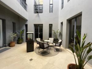 eine Terrasse mit Stühlen und einem Tisch in einem Gebäude in der Unterkunft YVES Marrakech in Marrakesch