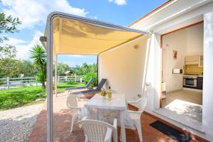a kitchen and dining area of a tiny house with a table and chairs at I Girasoli in Bari Sardo