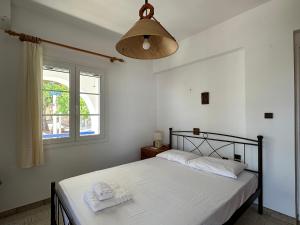 a bedroom with a bed with white sheets and a window at Molly’s Home in Víssa