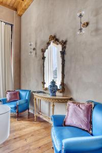 ein Wohnzimmer mit blauen Stühlen und einem Tisch mit einem Spiegel in der Unterkunft Relais Le Due Matote in Bossolasco
