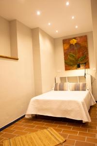 1 dormitorio con 1 cama y una pintura en la pared en Garza Imperial - Puente del Rey, en El Rocío