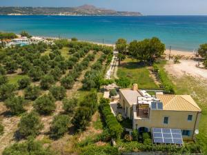 an aerial view of a house with solar panels on the beach at Calma Seaside Villa in Kalyves