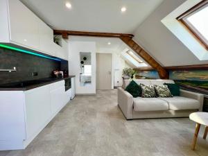 a living room with a couch and a kitchen at Natural Suite - Proche Gare - 4P in Belfort +9 photos