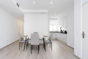 a white kitchen with a dining room table and chairs at EDEN RENTALS Top City Center in Santa Cruz de Tenerife