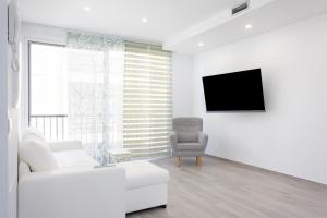 a white living room with a white couch and a chair at EDEN RENTALS Top City Center in Santa Cruz de Tenerife