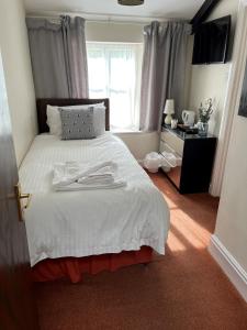 a bedroom with a large white bed with a window at Thorverton Arms in Exeter