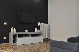 un soggiorno con TV su una parete nera di Big House Colosseo a Roma