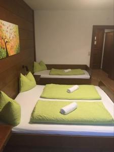 two beds in a room with lime green sheets and avertisement at Aineterhof in Ainet