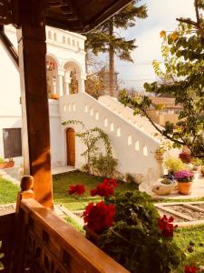 un jardin avec des fleurs rouges et un escalier blanc dans l'établissement Conacul Grigorescu, à Răteşti