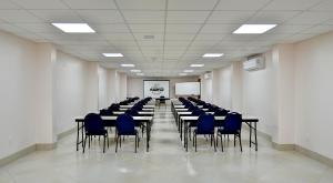 a conference room with tables and blue chairs at Hotel Bons Tempos in Rio Verde