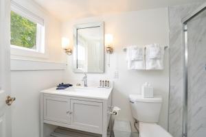 a white bathroom with a toilet and a sink at Kent Island Resort in Stevensville