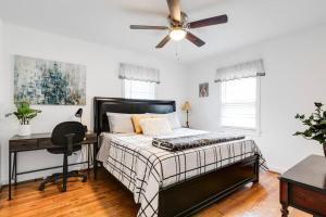 a bedroom with a bed and a desk and a ceiling fan at RF Central location w fenced backyard FIRE-PIT in Richmond