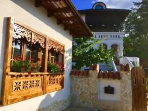 a building with two windows with flowers on it at Conacul Grigorescu in Răteşti
