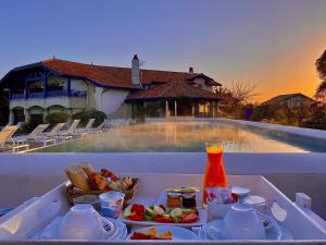 ein Tablett mit Essen auf einem Tisch neben einem Pool in der Unterkunft Villa L'Arche in Bidart