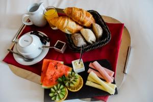 ein Frühstückstablett mit Brot und einem Korb mit Gebäck in der Unterkunft Hotel Premium Porto Downtown in Porto